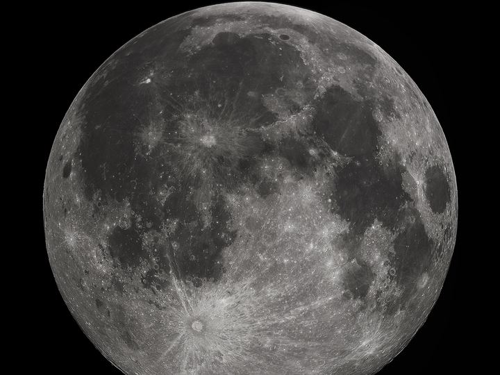 A sharp, detailed photograph of the full Moon showing dark maria and bright cratered highlands