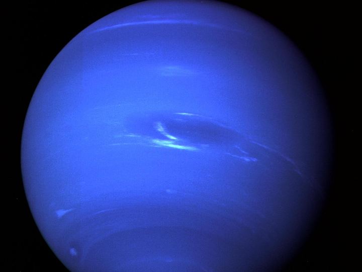 Neptune as a deep blue globe with the dark oval Great Dark Spot and streaks of white clouds