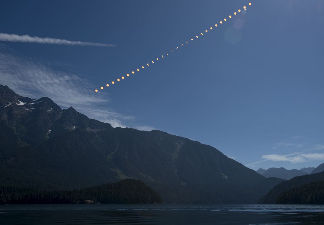 The Moon fully covering the Sun during a total solar eclipse, with the pale white corona streaming outward